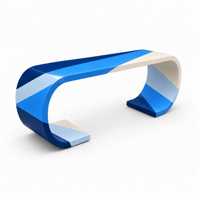striking modern waterfall console featuring sweeping curves and a bold, custom geometric finish. Deep navy, vibrant blue,...