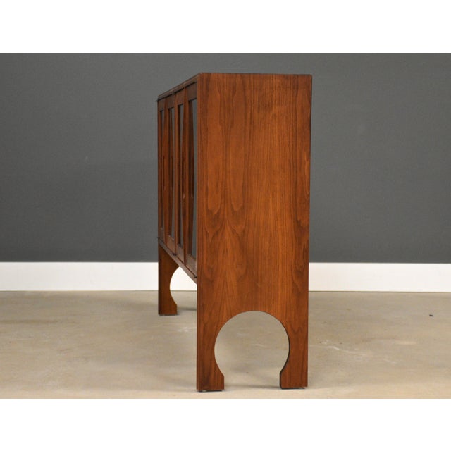 A mid century modern walnut bookcase or display cabinet with four glass doors. Circa 1960’s. Made in USA. One minor...