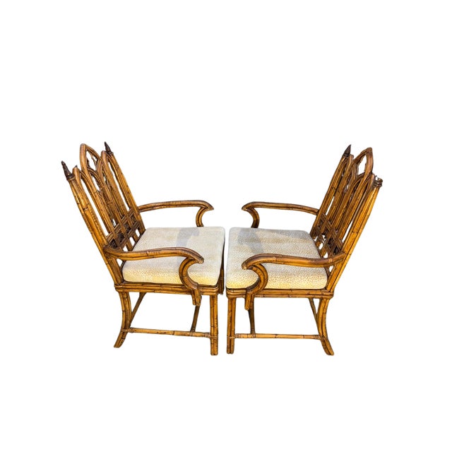 A decorative pair of 20th century English faux bamboo armchairs in the Gothic taste. Featuring pointed arch backs with...