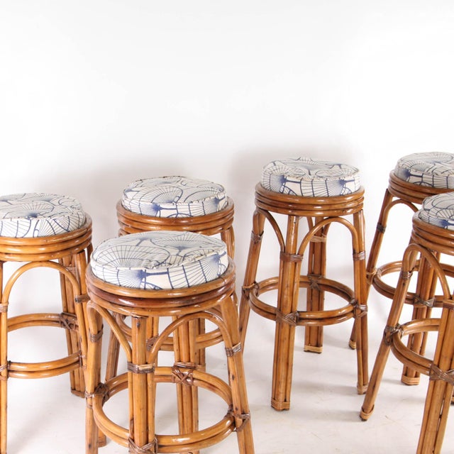 Rare set of six rattan bar stools from the 1970s. Featured with seat cushions upholstered in a lovely removable blue and...