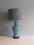 The gray-blue ceramic lamp base has a very beautiful crackle and is mounted on a black wooden base. The lamp has an E 27...
