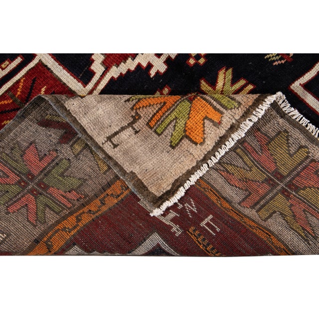Beautiful vintage Azeri hand-knotted wool runner with a red field. This rug has multi-color accents in a gorgeous all-over...