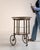 A stylish mid-century bar cart combining a brass frame with glass shelves, reflecting the light and elegant aesthetic of...