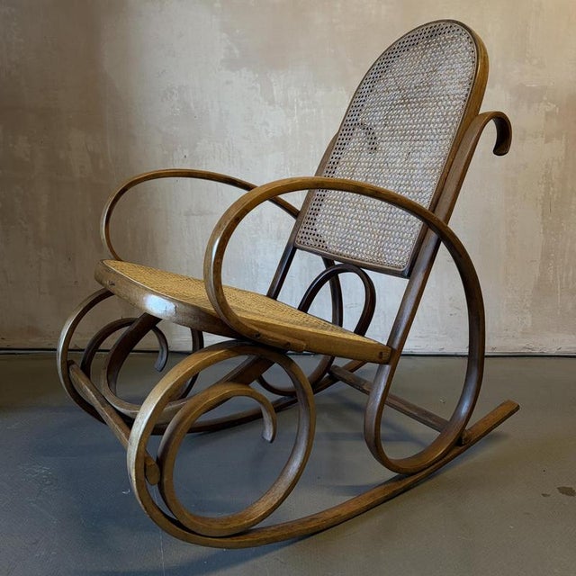 Vintage bentwood and cane Thonet style rocking chair. Approximate dimensions: Width: 55cm Depth: 90cm Height: 98cm Seat...