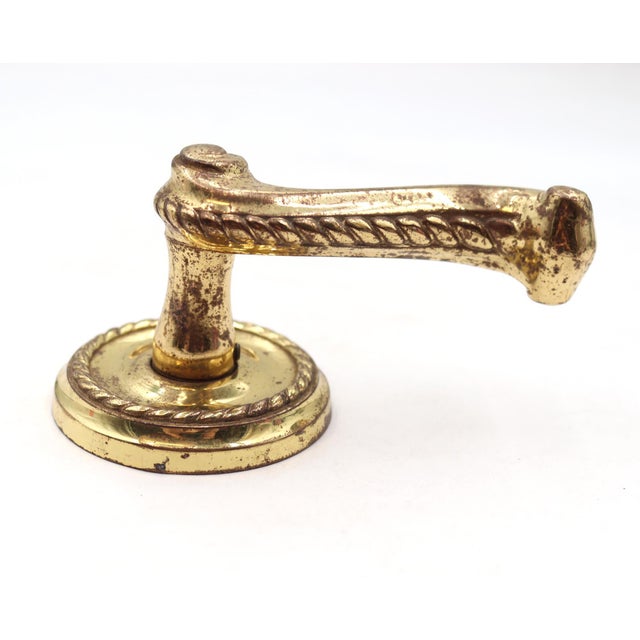 Modern brass braided door lever paired with a round rosette. The original rosette mounting screws are not available. Good...