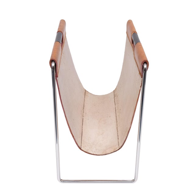 Stylish magazine holder with a chrome base and a cognac-coloured stitched leather basket, showing just the right amount of...