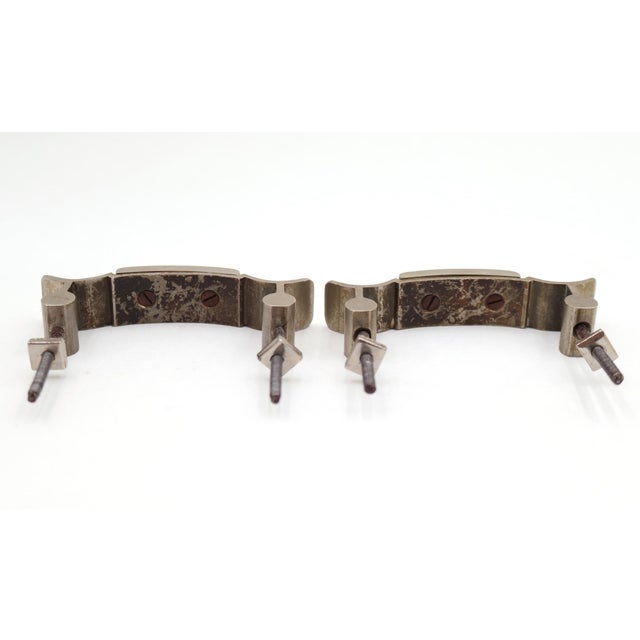 Unique shaped bridge drawer pulls made of brass with a brushed nickel finish. The original mounting nuts are included....