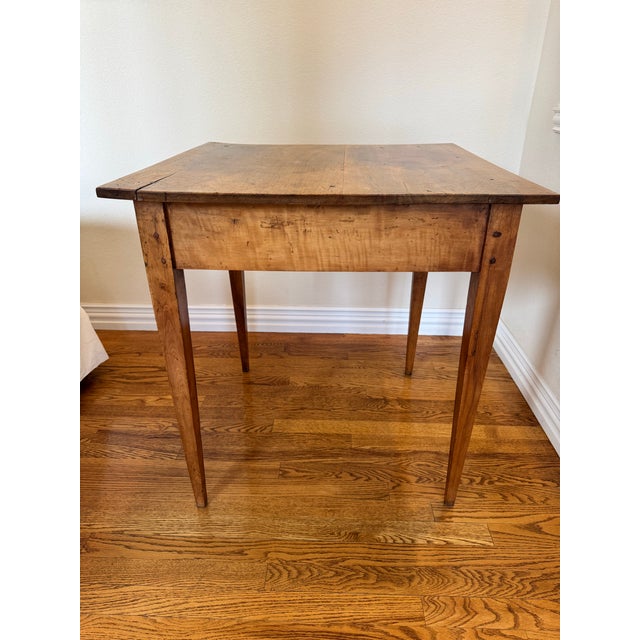 The French Louis Phillipe mixed wood diminutive baking table having a square walnut top over the conforming tiger maple...