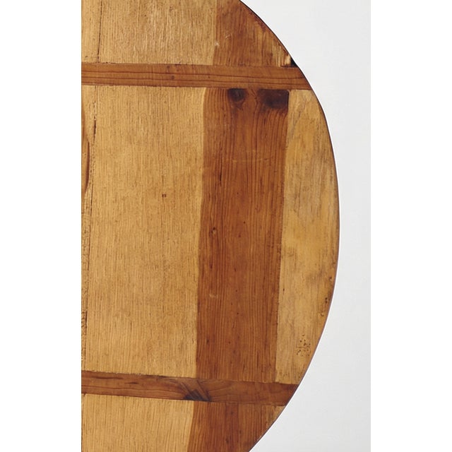 A beautiful example of rustic utility, this antique round bread board features warm, time-worn wood with visible joinery...