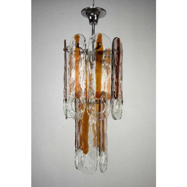 Elevate your space with this iconic "occhio" model chandelier, produced by the world-renowned mazzega glassworks in...