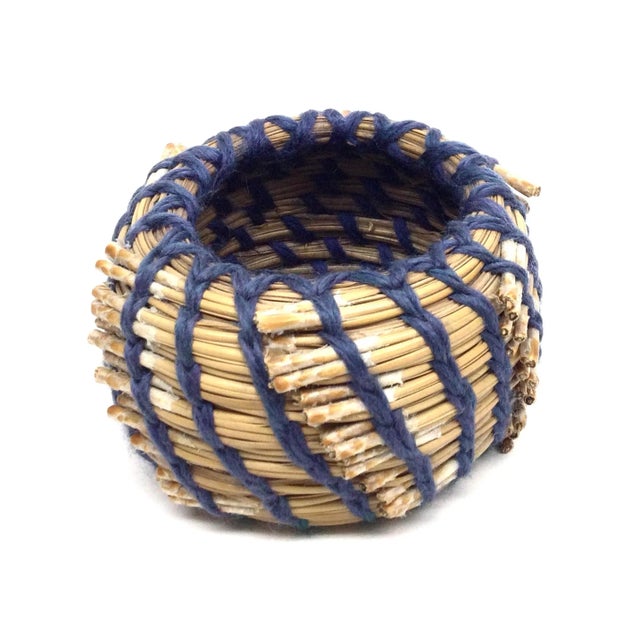 Rustic style hand woven small basket intertwined with yarn to hold it together. Unusual design and very primitive way of...