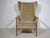 Vintage wingback chair with a folding mechanism from the 1970s. High backrest with side wing panels, solid wood frame, and...