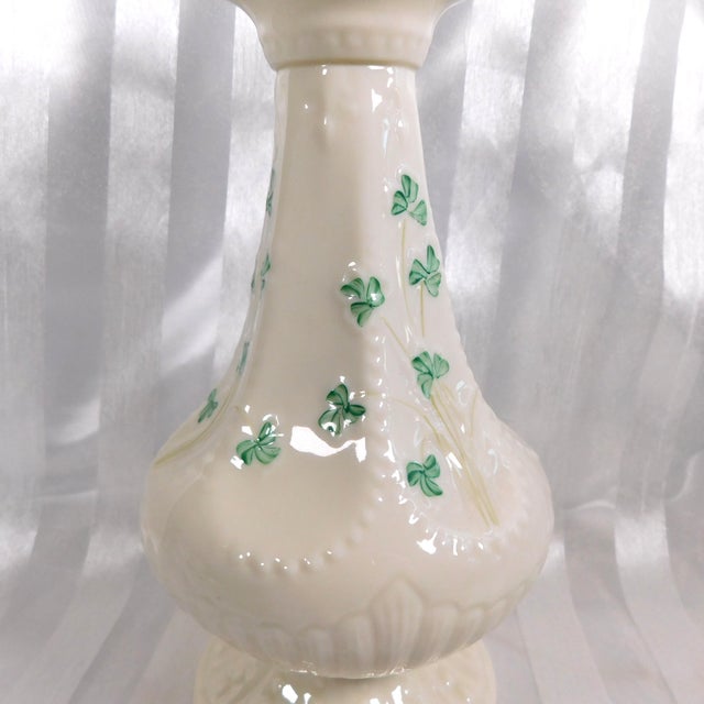 This is a Belleek eight inch island vase in the Shamrock pattern from 1946. The vase is off white with green leaves and a...