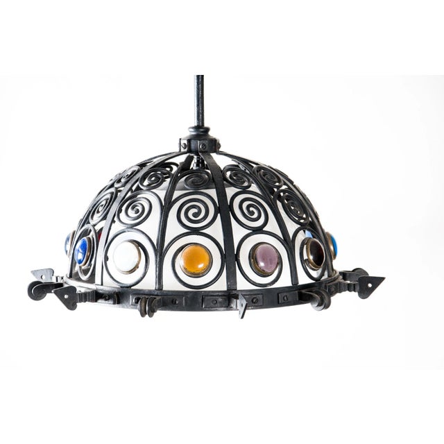Wrought iron and colored glass jeweled lighting fixture. Spikes and pulleys around. Rewired electrical. Dome shaped. In my...