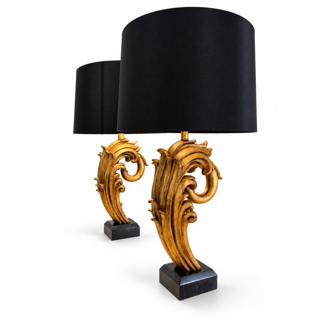 A striking pair of sculptural table lamps featuring sweeping, leaf-inspired forms in a warm gold finish. Each lamp rests...