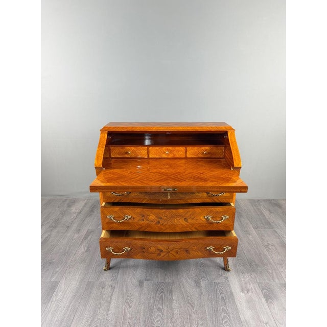 An elegant Louis XV style drop-front secretary desk, dating from the late 19th century. The desk features a richly...