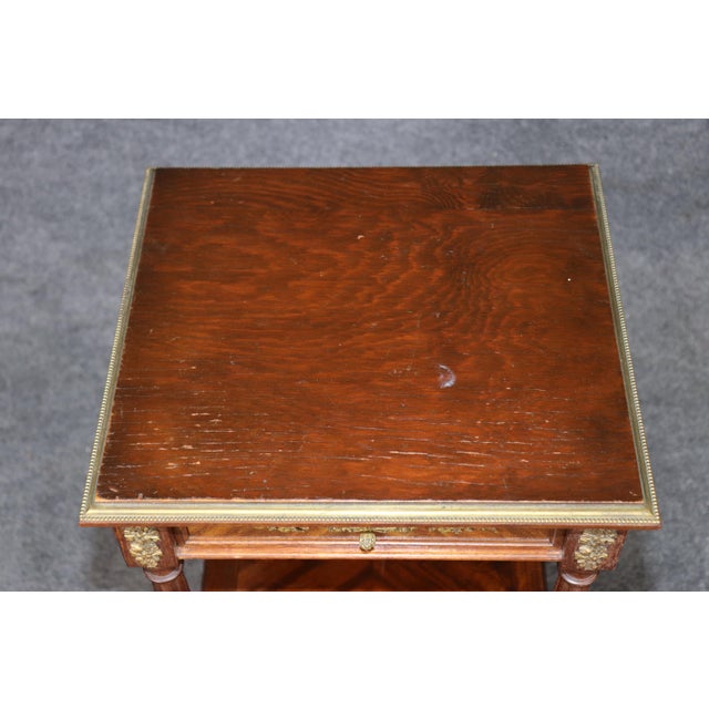 This exceptionally decorative pair of French Louis XVI and Directoire-style nightstands, executed in richly figured walnut...