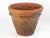 A large antique terracotta pot featuring a wide flared rim and a decorative rope twist detail encircling the upper body....