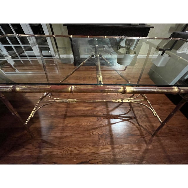 Stunning and rare vintage 1970s Hollywood Regency dining table featuring a distressed, gilded (gold tone) finish over a...