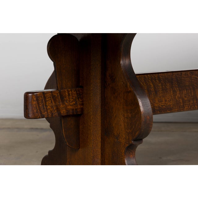 An early 20th-century French oak monastery trestle dining table, sourced in Lyon, France. Distinguished by its substantial...