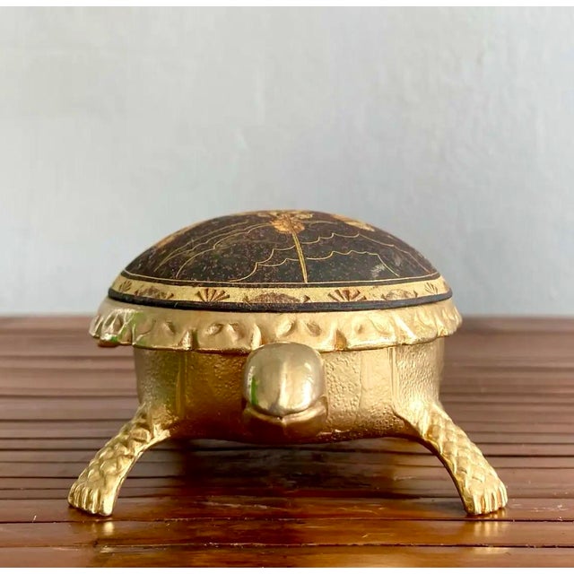 Unique and charming, this vintage brass trinket box is shaped like a turtle and features an intricate etched depiction of...