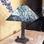 Distinctive 2003 Tiffany-style table lamp with a dramatic pyramid-shaped stained-glass shade featuring floral and...