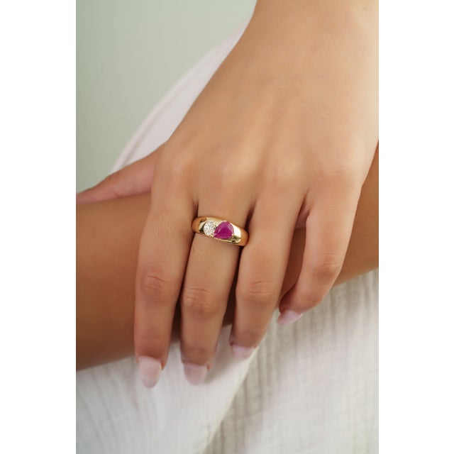 This cigar band ring features a 1.2 carat natural pear-cut ruby, set in 14K yellow gold. The ruby measuring approximately...