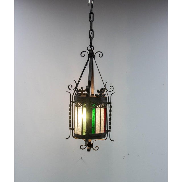 Art nouveau period chandelier or lustre, french wrought iron, colored red and green glass, white glass is granite-glazed...