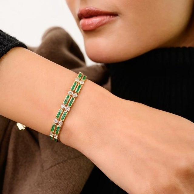This double-row tennis bracelet features square cut emeralds totaling 5.03 carats, set in rich 14k yellow gold. Each...