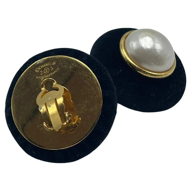 Chanel clip-on earrings in velvet. This one-of-a-kind set of Chanel earrings has a pearl in the middle encircled by a thin...