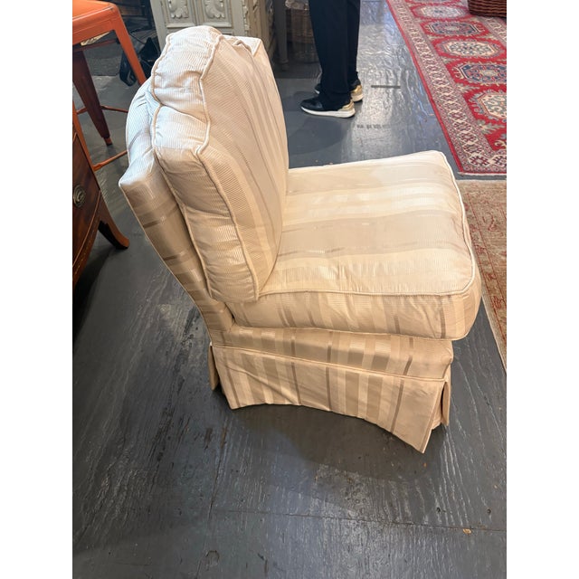 This is a lovely vintage slipper chair with wheels on the bottom. The original silk fabric has a subtle striped pattern....