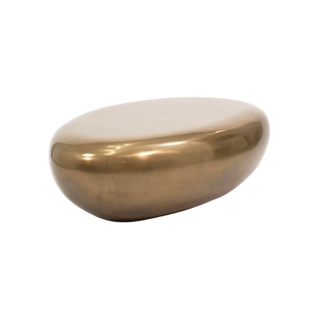 The Riverstone Gold Leaf Egg Shaped Coffee Table by Phillips Collection is a striking blend of organic form and refined...