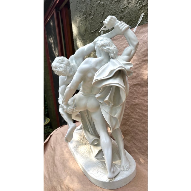Here we have a porcelain sculpture of a pair of wrestlers with a knife in one hand , originally sculpted by Johan Peter...