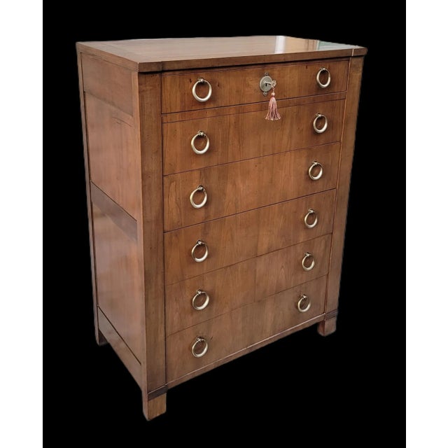 Featured is a gorgeous French Empire style six-drawer highboy dresser by Baker Furniture , circa 1960s. Lovely book-...