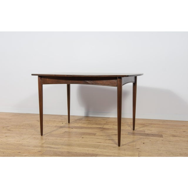 This extending dining table was manufactured by the British furniture maker White & Newton during the 1960s. The piece is...