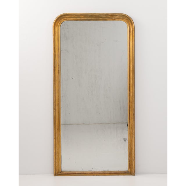 A 19th century French floor mirror in the Louis Philippe style, defined by its tall vertical format and softly curved...