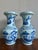 This elegant pair of blue and white porcelain vases features traditional hand-painted Chinese landscape scenes rendered in...