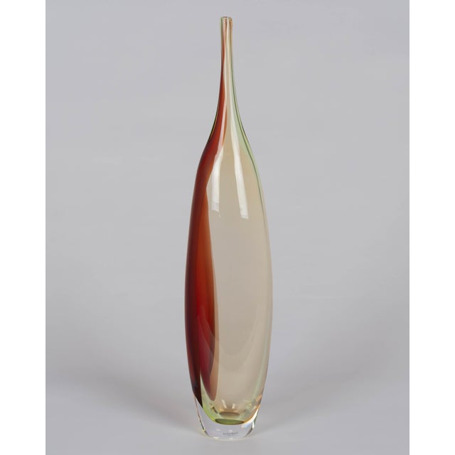 A Kosta Boda "Tobago" art glass vase designed by Kjell Engman. Tall, slender silhouette with slightly oval form and...