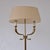 Neoclassical brass floor lamp attributed to maison jansen, featuring twin curved candle arms with dolphin-head details....