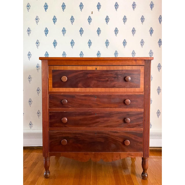 With the lighter color of its cherry case contrasting with the darker, beautifully figured mahogany of its drawer faces,...