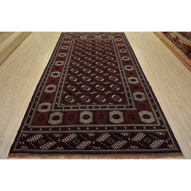 An authentic vintage tribal Turkmen rug hand-knotted with fine wool and natural dyes. This nomadic rug features rows of...