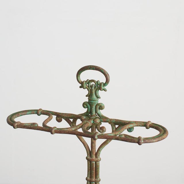 A stunning decorative cast iron umbrella and stick stand with four curved divisions at the top which will hold multiple...