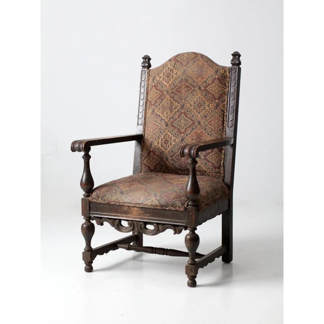 This is an antique Louis XIII style arm chair from the 19th century. Decoratively carved, the wooden arm chair features a...
