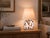 Crafted with high visual clarity, this modern table lamp features a sleek silhouette with a hand-blown glass base paired...