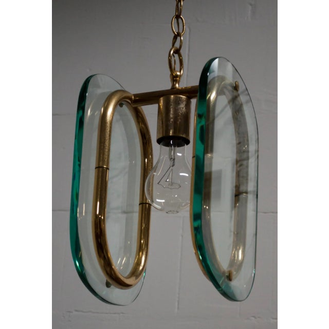 This vintage pendant lamp was designed and produced in the 1950s. Reminiscent of the style of Fontana Arte. It has a brass...
