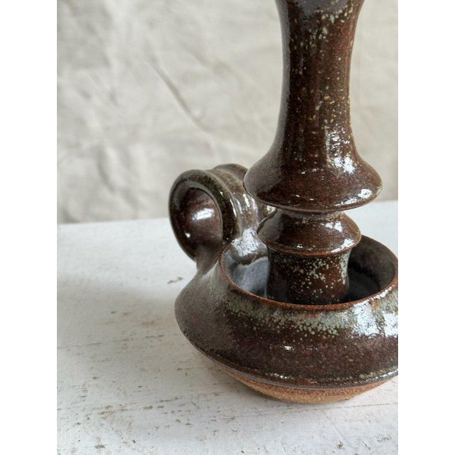 This vintage brown ceramic candle holder boasts a rich, dark brown hue, adding a touch of sophistication to any space. Its...