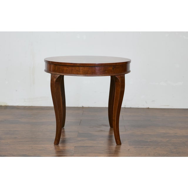 An Italian walnut round top table with cabriole legs. This Italian walnut round top table captures the eye with its...