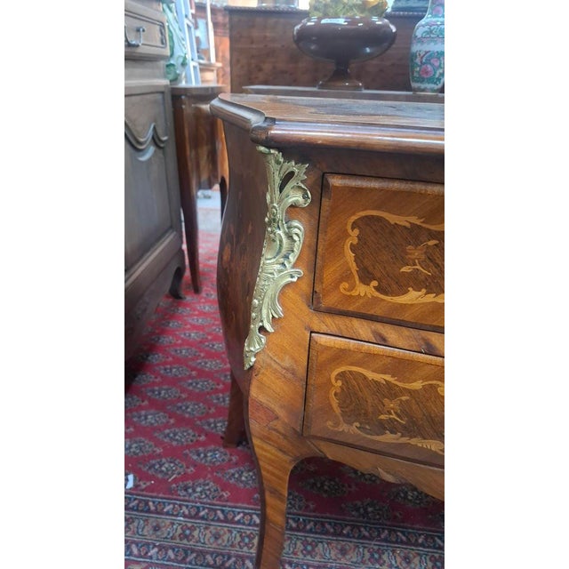 Small marquetry chest of drawers resting on two drawers. It has a key. This chest of drawers is curved on the front and...