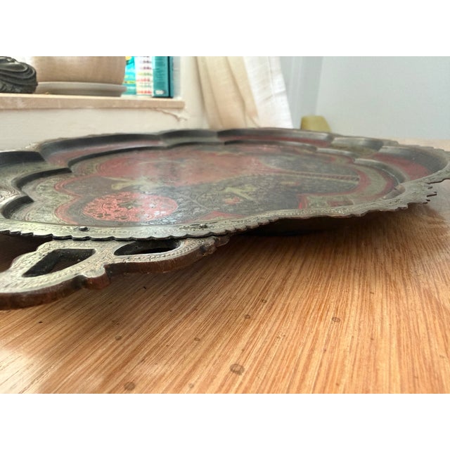 An exquisite vintage Indo-Persian hand-etched brass tray featuring vibrant hand-filled red, dark navy, and subtle green...