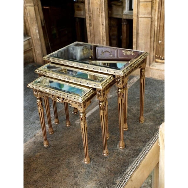 Add a touch of timeless elegance to your interior with this exquisite set of three vintage Louis XVI-style nesting tables....